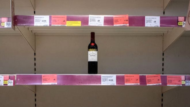 Бутылка вина на пустой полке супермаркета
