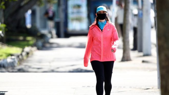 A woman walking wearing a mask in Auckland