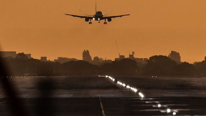 Пассажирский самолет готовится к посадке во время восхода солнца в лондонском аэропорту Хитроу