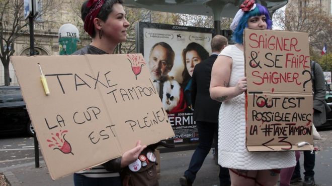 Женщины держат в руках плакаты с надписью «Налог на тампоны, чашка наполнена» во время демонстрации в Париже в ноябре, призывающей к снижению налогов на тампоны и женские гигиенические товары.