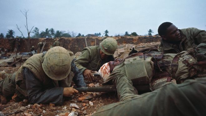Морские пехотинцы США выталкивают одного из своих раненых за пределы зоны действия во время войны во Вьетнаме