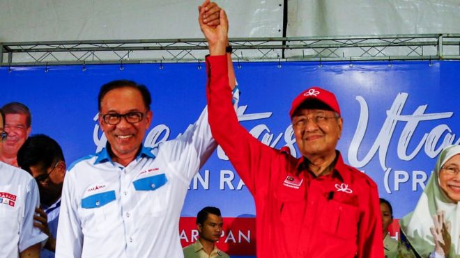 Премьер-министр Малайзии Тун Махатхир Мохамад (3-й слева) поднимает руку Анвара Ибрагима (3-й слева) во время предвыборной кампании в Порт-Диксоне, Малайзия, 8 октября 2018 года