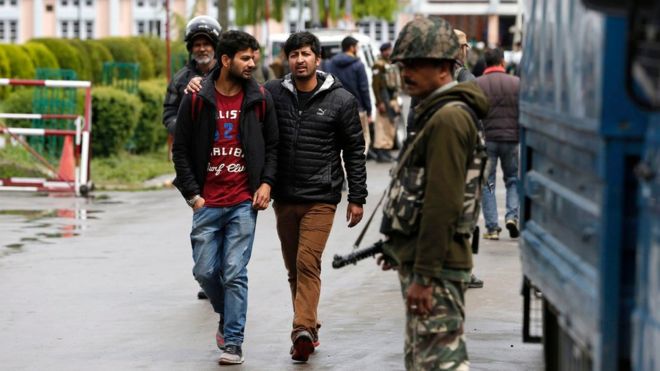 Студенты проходят мимо индийских военизированных солдат Центральных резервных полицейских сил (CRPF) в Национальном технологическом институте (NIT) в Сринагаре, летней столице Индии, управляемой Кашмиром, 06 апреля 2016 года