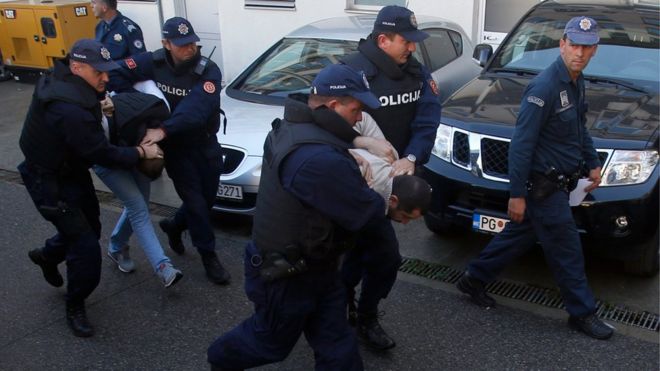 Черногорские полицейские сопровождают мужчин для допроса в Подгорице