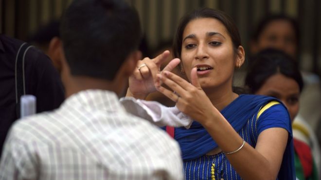 Индийские глухие активисты взаимодействуют с языком жестов во время акции протеста в Нью-Дели 5 мая 2015 года
