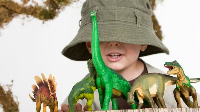 Ребенок играет с динозаврами