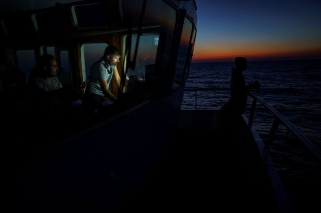 Глава миссии НПО Proactiva Open Arms Риккардо Гатти отслеживает положение резиновой лодки в центральной части Средиземного моря