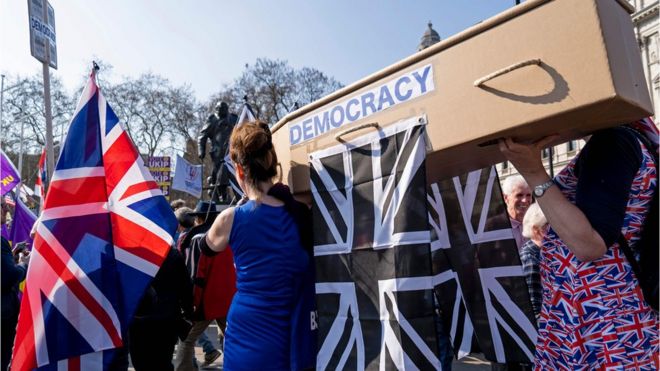 Демонстранты, выступающие за Брексит, несут гроб с изображением смерти демократии, когда протестующие собираются на площади Парламента в центре Лондона