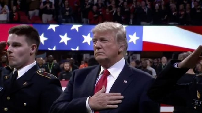 Дональд Трамп исполняет гимн США на футбольном матче.
