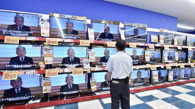 A man looks at television screens showing a speech by Japanese Emperor Akihito to the nation, are displayed at an electronic shop in Tokyo on August 8, 2016.