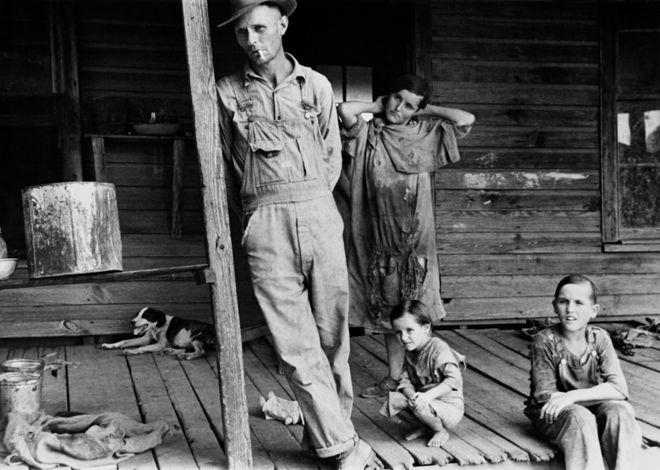 Семья на крыльце во время американской депрессии.