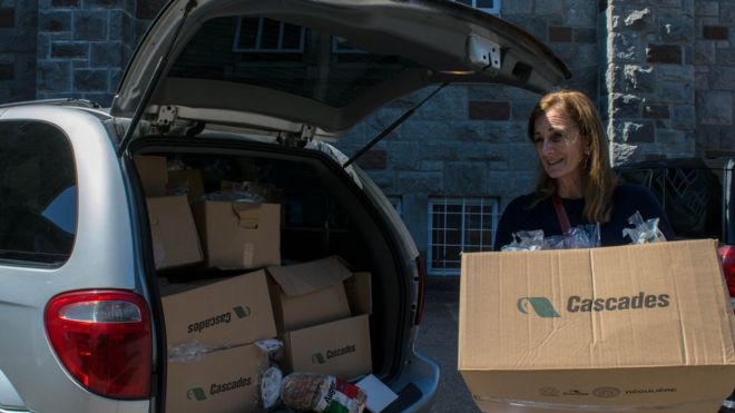 Рэйчел Лапьер разгружает машину, полную хлеба, для раздачи семьям беженцев