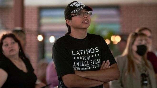 Un joven con una camiseta que dice "Latinos for America" asiste a un acto de campaña de Monica de la Cruz y Mayra Flores, candidatas republicanas a la Cámara de Representantes por el Valle del Río Grande, el 10 de octubre en la Universidad Drafthouse en McAllen, Texas.