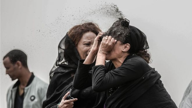 Familiar de una víctima del accidente de avión de Ethiopian Airlines arrojándose tierra a la cara.