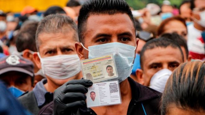 Venezuelanos usando máscaras tentam atravessar fronteira com a Colômbia