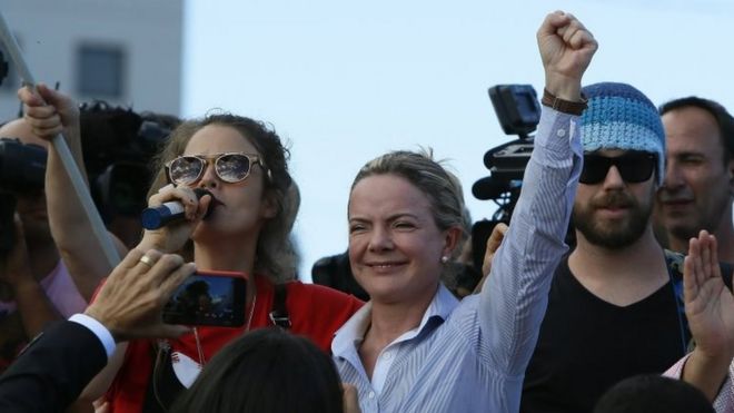 Бразильская певица Ана Канас (слева) и президент Рабочей партии Глейси Хоффманн (слева) принимают участие в митинге сторонников бывшего президента Бразилии Луиса Инасиу Лула да Силвы возле штаб-квартиры Федеральной полиции в Куритибе, Бразилия, 8 апреля 2018 года