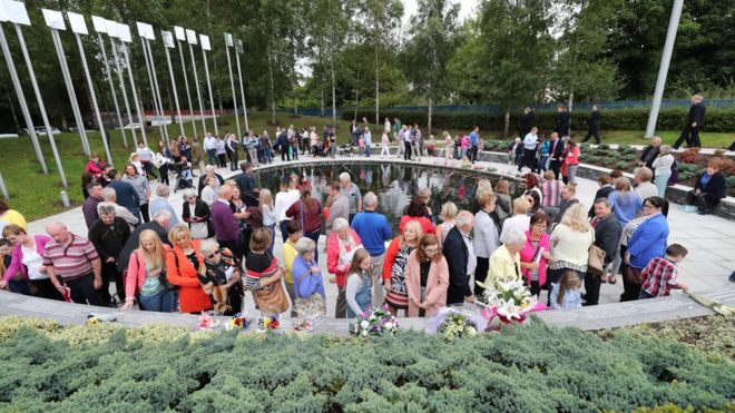 Люди присутствуют на церемонии, посвященной 20-летию бомбы Ома
