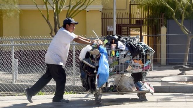 9 февраля 2016 года мужчина толкает тележку с вещами по улице в Лос-Анджелесе, штат Калифорния.