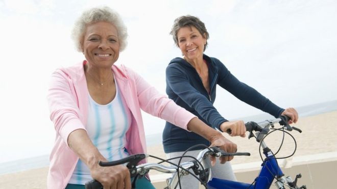 Dos mujeres mayores en bicicletas en una playa