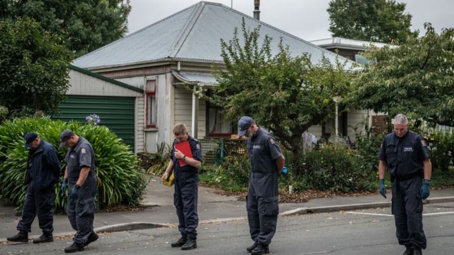 A line of police officers search a road nearthe Al Noor mosque, site of one of the attacks, in Christchurch