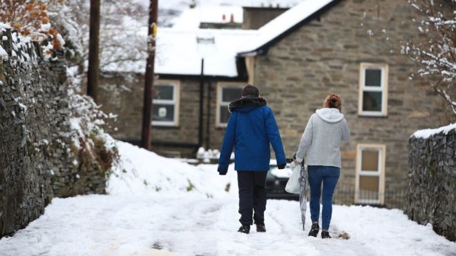 Люди гуляют на снежных условиях в Blaenau Ffestiniog в Уэльсе