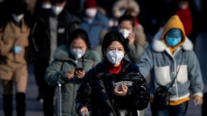 Travellers in Beijing all wearing facemasks