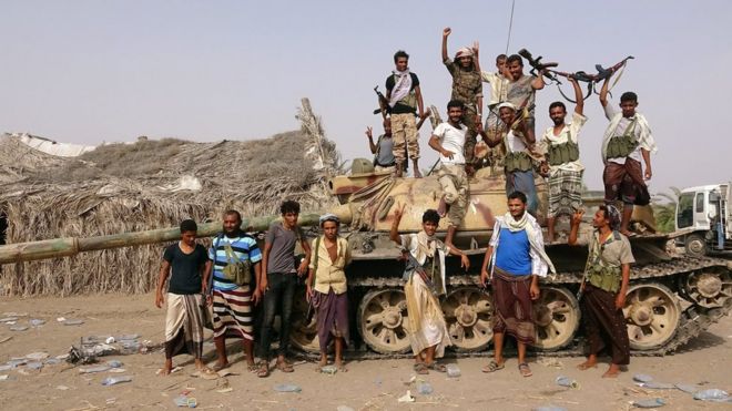 Бойцы племен, связанные с правительством Йемена, стоят возле танка возле Худайды (1 июня 2018 года)