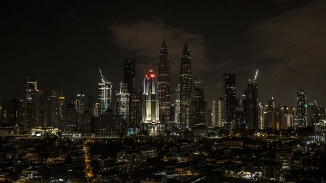 A view of the Petronas Towers (C) with light off during Earth Hour in Kuala Lumpur, Malaysia