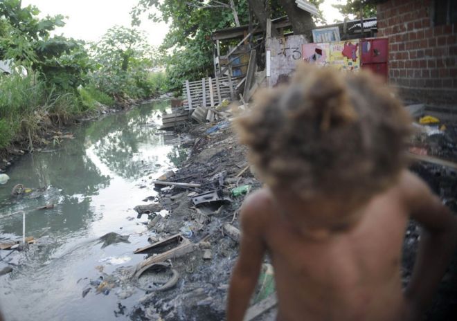 Esgoto e criança em favela