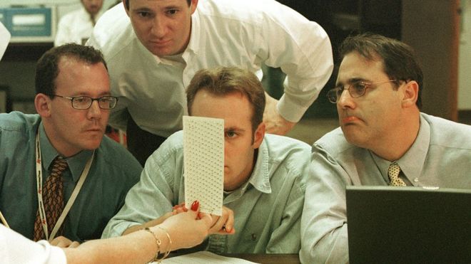 Broward County Election employees, reporters and Judicial Watch members look at ballot papers December 18, 2000