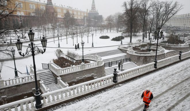 Рабочий гуляет возле Кремля после снегопада в центре Москвы (30 ноября)