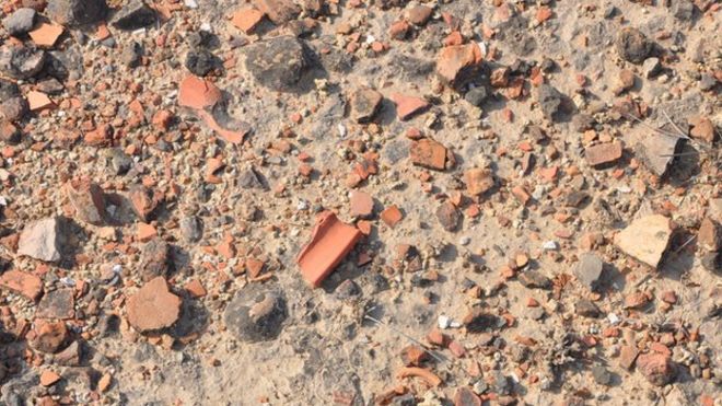Разбитые куски керамики Инда выставлены на поверхности в Калибанган