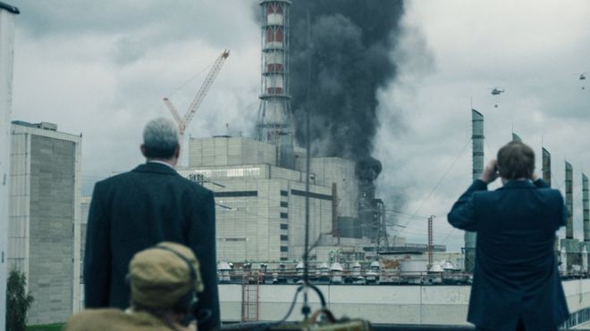 Сцена из Чернобыля, на которой актеры смотрят на дым, исходящий от электростанции