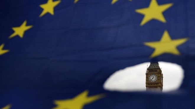 Big Ben is seen through a hole in an EU flag in London. Photo: 29 March 2017