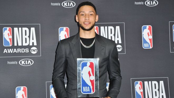 Ben Simmons poses with his 2017-2018 NBA Rookie of the Year award at a media event