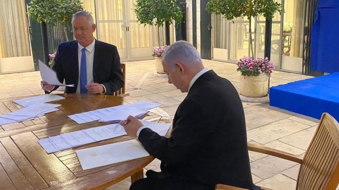 Benny Gantz (left) and Benjamin Netanyahu (right) sign a coalition deal in Jerusalem on 20 April 2020