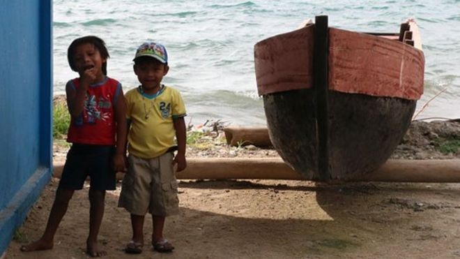 Niños guna junto a una canoa en Panamá.