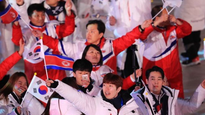 Делегации из Северной и Южной Кореи маршируют под флагом объединения Кореи