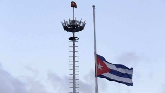 Кубинский флаг развевается наполовину на мачте на площади Революции в Гаване