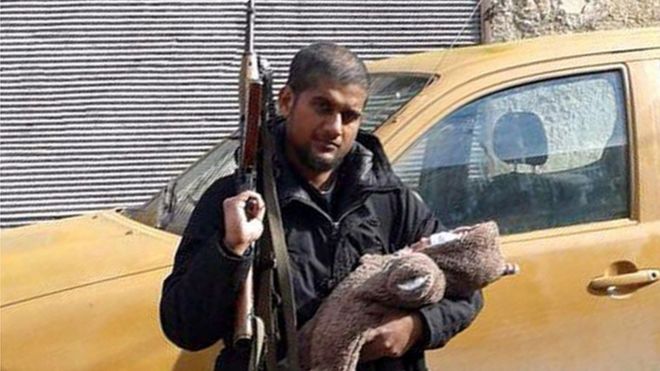 Мужчина, которого считали Сиддхартха Дхар, он же Абу Румайса, с ребенком на руках и винтовкой АК47 в 2014 году
