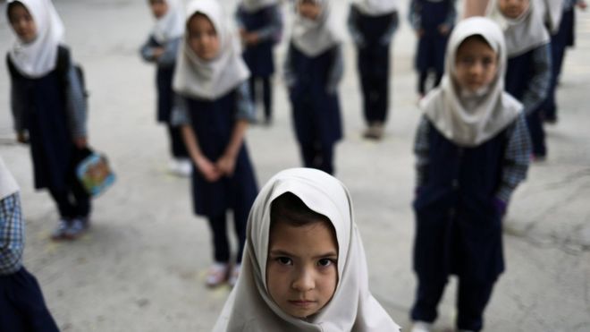 Afghan girls look on at a school in Kabul, Afghanistan