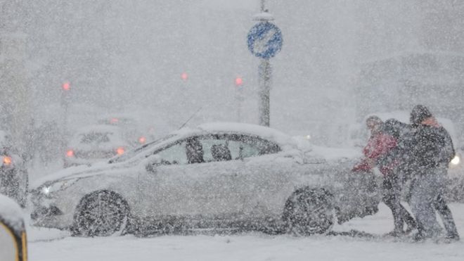 Автомобиль выталкивают из снега в Рочестере, Кент, Великобритания