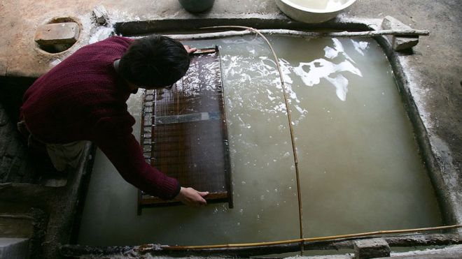 Рабочий фильтрует целлюлозу на фабрике по производству бумаги ручной работы в Сиане, провинция Шэньси, Китай