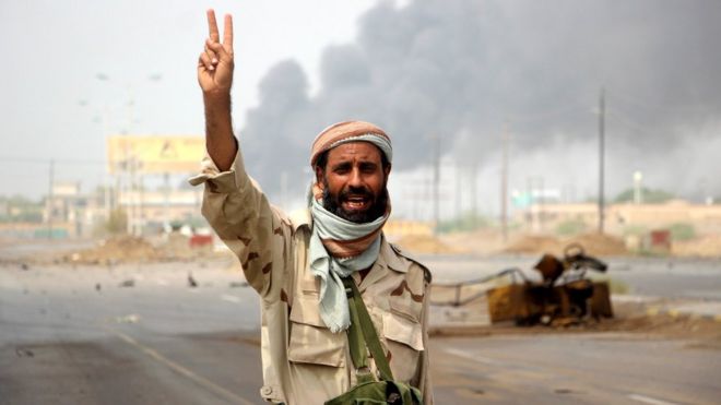 أحد أفراد القوات الموالية لهادي يلوح بعلامة النصر