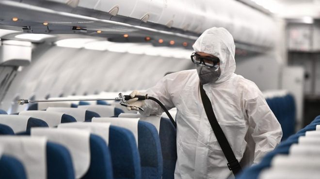 Man spraying plane with disinfectant