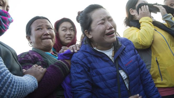 Родственники реагируют как вертолет, несущий мертвые тела альпинистов на вертолетной площадке Учебного госпиталя в Катманду, Непал