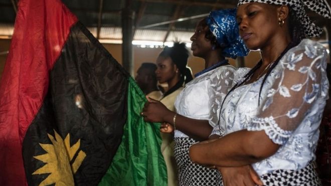 Женщина держит флаг Биафрана во время службы в католической церкви Святого Мартина 28 мая 2017 года в районе Аба-Юг в городе Аба.