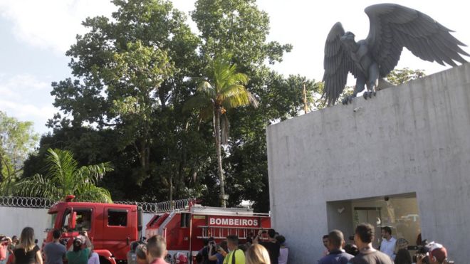 Pessoas na frente do Centro de Treinamento do Flamengo em Vargem Grande, no Rio de Janeiro