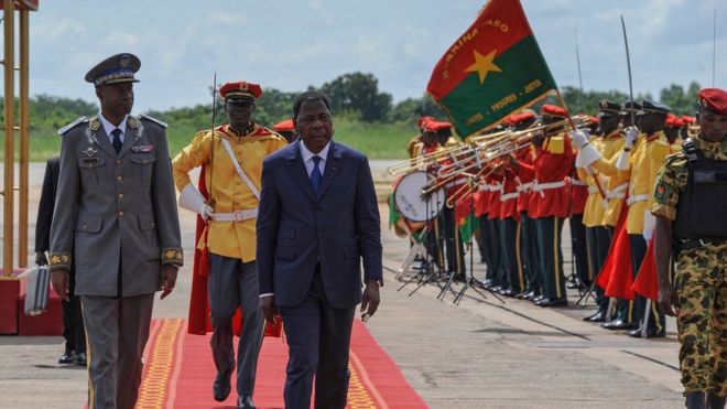 Лидер переворота Буркина-Фасо генерал Гилберт Диендере (слева) во время прогулки с президентом Бенина Яи Бони (третий слева) вскоре после прибытия в аэропорт столицы Уагадугу, Буркина-Фасо,