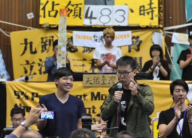 Лидеры протеста студентов Чэнь Вэйтин (спереди слева) улыбается, когда Лин Фэй-фан (справа) говорит в Парламенте, поскольку более 200 протестующих - в основном студенты - занимают здание в Тайбэе 6 апреля 2014 года.